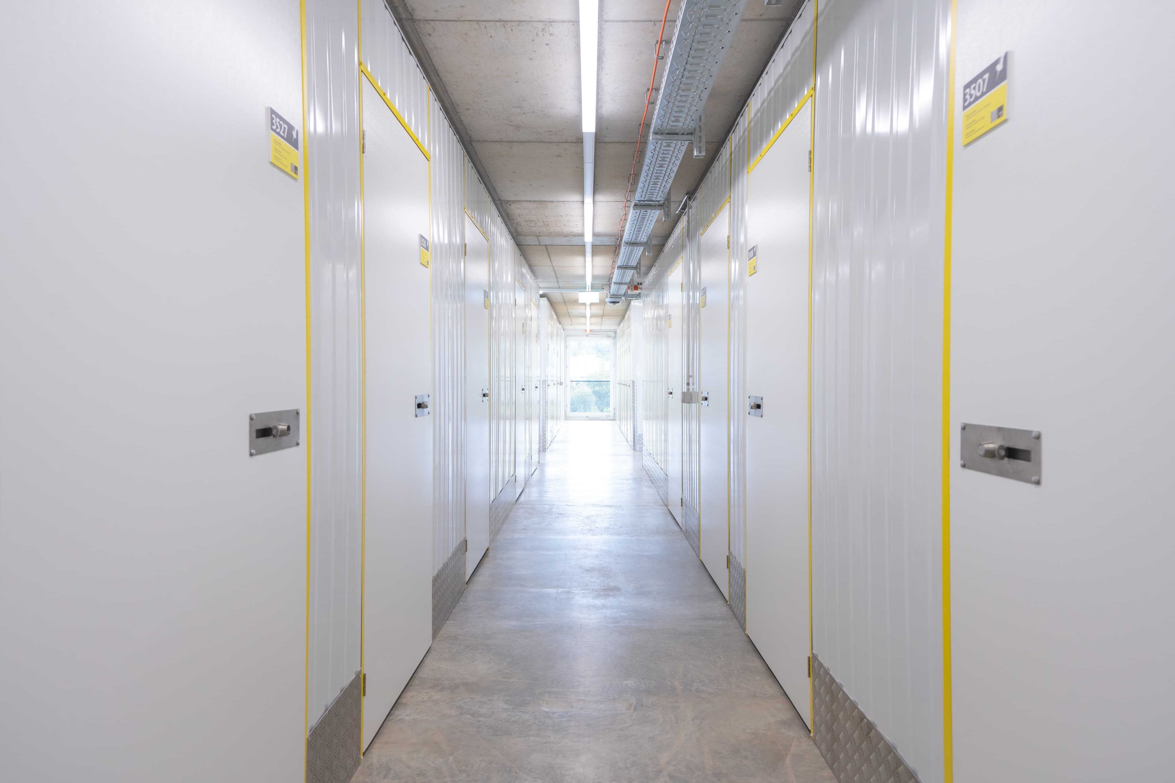Interior view of the Zebrabox warehouse with individual storage units. The walls are made of sturdy white steel with yellow-edged doors.