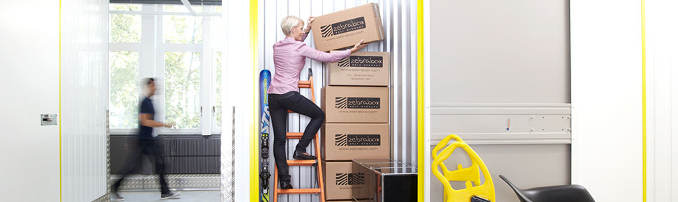 Frau steht in ihrem Lagerraum bei Zebrabox Frau steht in ihrem Lagerraum bei Zebrabox
