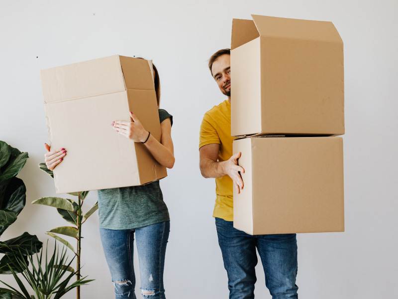 Un jeune couple range efficacement son espace de stockage Un jeune couple range efficacement son espace de stockage