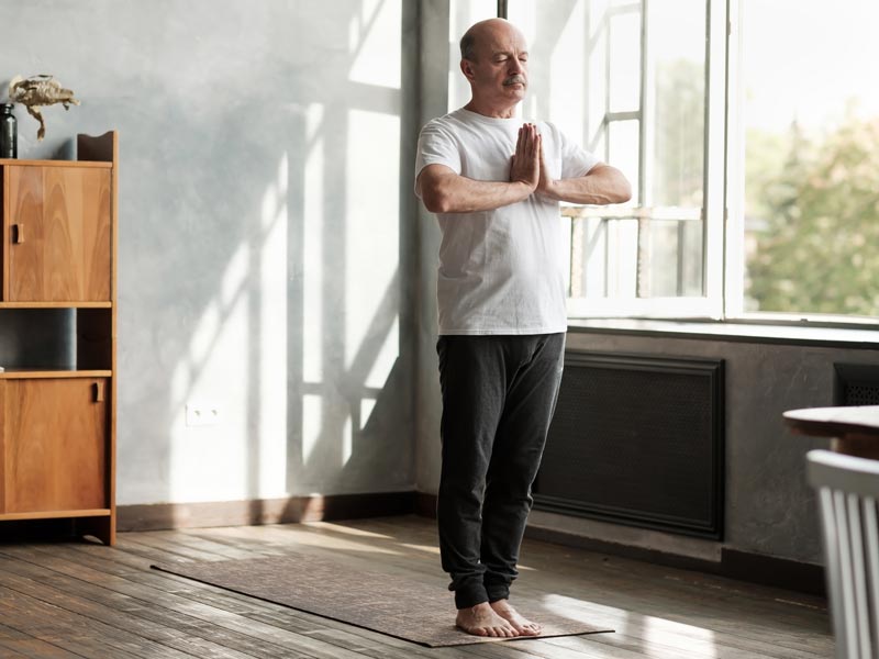 Älterer Mann macht Yoga bei frischer Luft